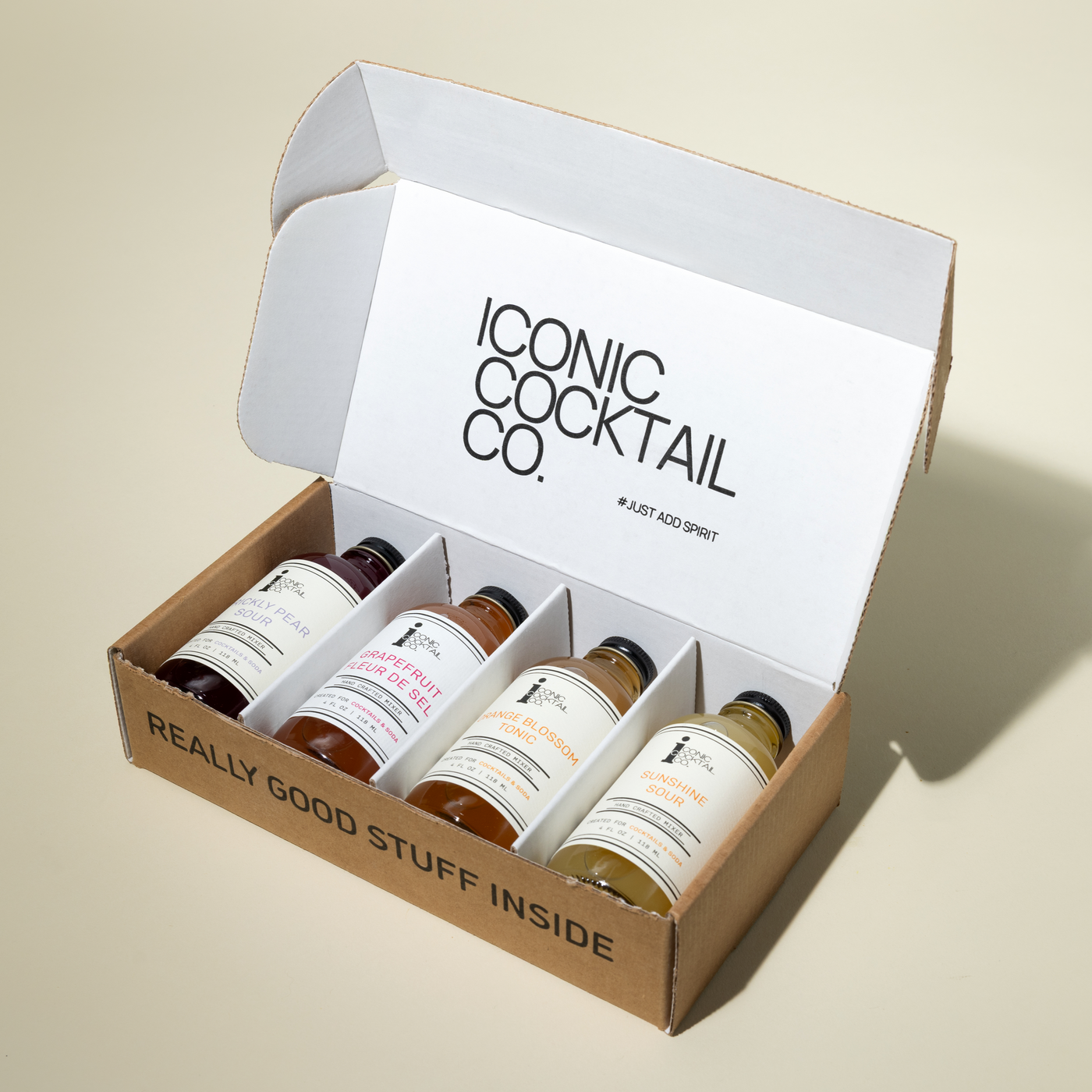 Box of cocktail ingredients from Iconic Cocktail Co. on a beige background